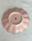 Rinka Plate 17cm in pink porcelain, handcrafted in Japan, showcasing scalloped edge design on a textured surface.