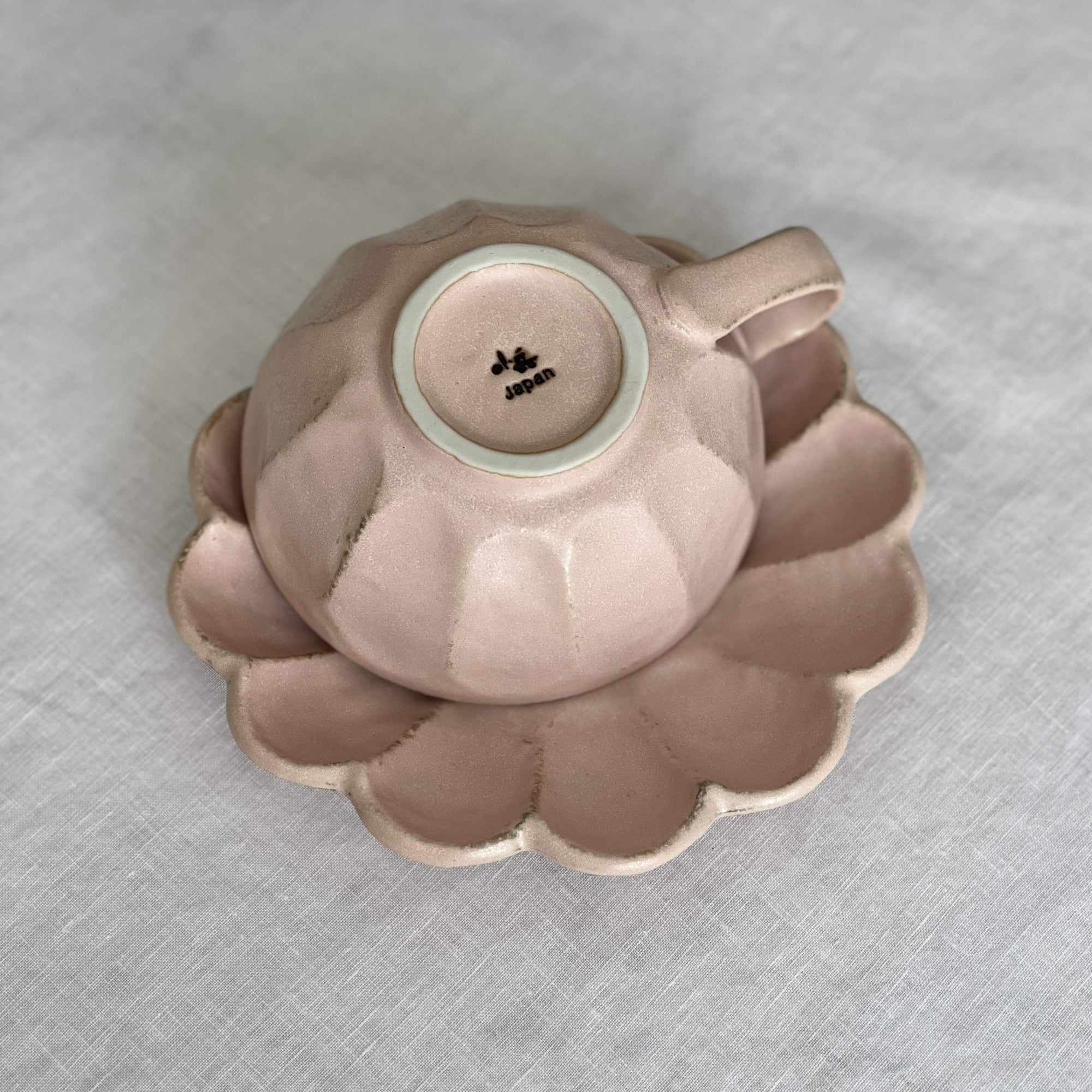Rinka Soup Cup in pink porcelain with flower shape, part of Kaneko Kohyo collection, elegantly displayed on matching saucer.