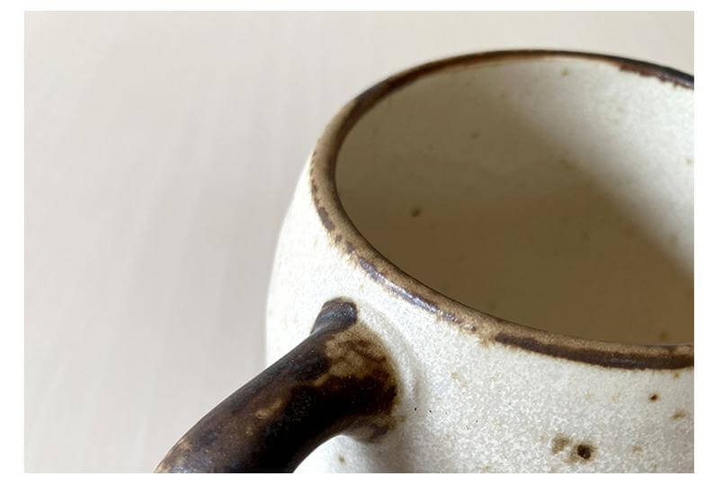 Close-up of Rila Ivory Mug's textured porcelain surface and handle, showcasing its warm, matte finish from Kaneko Kohyo factory.
