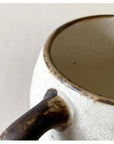 Close-up of Rila Ivory Mug's textured porcelain surface and handle, showcasing its warm, matte finish from Kaneko Kohyo factory.