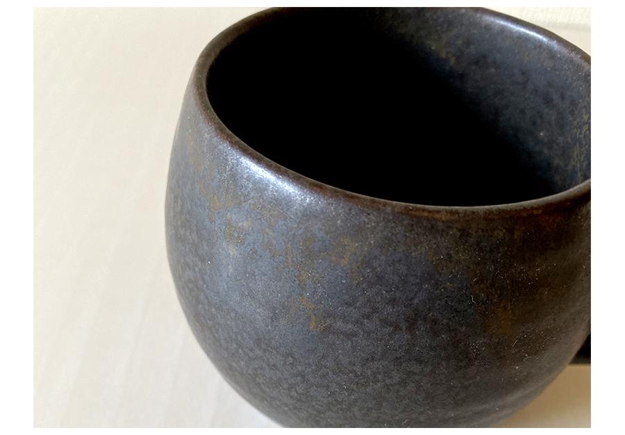 Textured black porcelain mug by Kaneko Kohyo, close-up view showing matte finish and elegant design, perfect for coffee or tea.