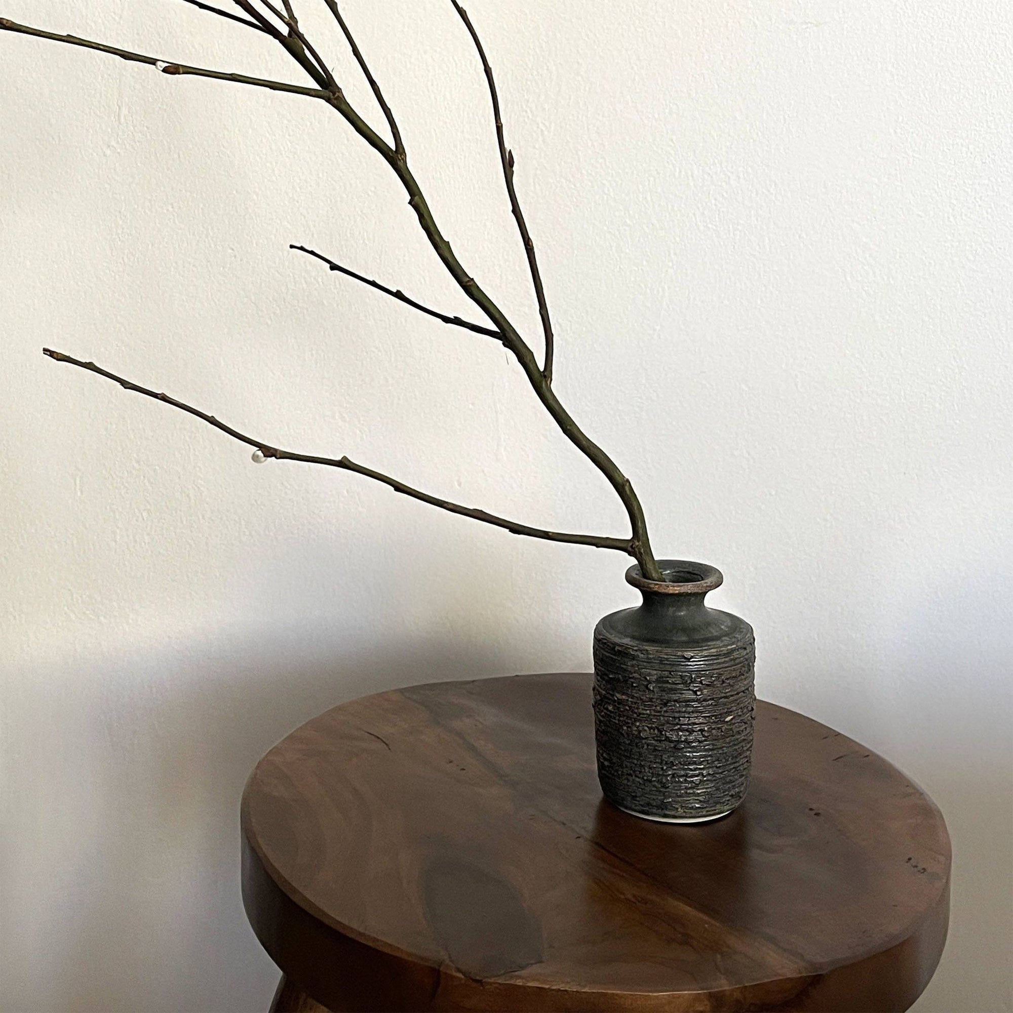 Shabby Chic Green Vase from Yoshida Pottery Collection on wooden table with branches, crafted by ceramist Masakazu Yoshida.