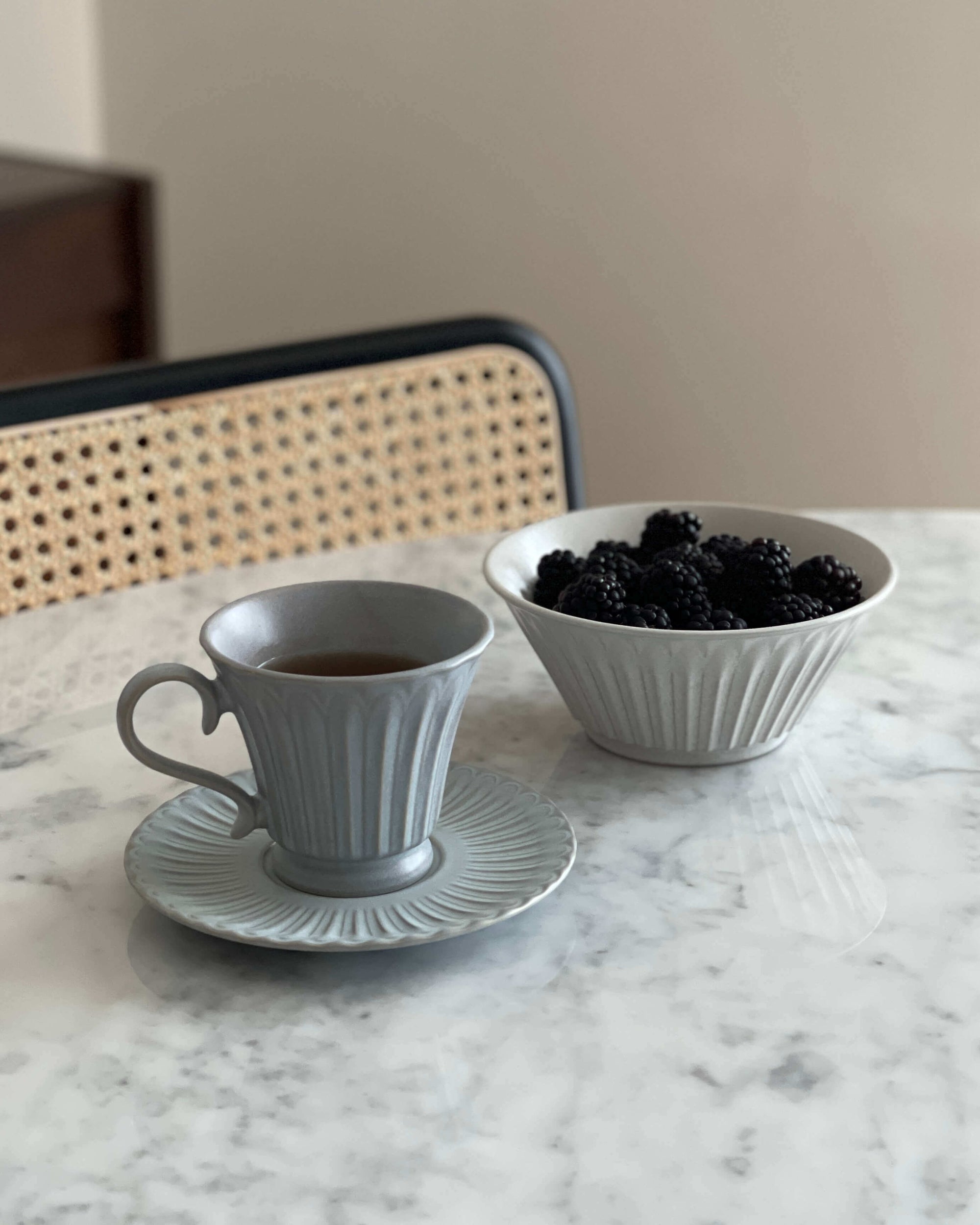 Storia Tall Coffee Cup & Saucer with blackberries on a marble table, showcasing elegant and nostalgic porcelain design.
