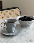 Porcelain cup and Storia Bowl with blackberries on marble table for elegant dining ambiance.