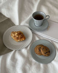 Elegant porcelain plates with cookies and croissant, paired with a teacup on soft linen, evoke nostalgia and romance.