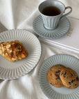 Elegant porcelain plates with pastries and tea cup, evoking nostalgia and sophistication in a cozy dining setting.
