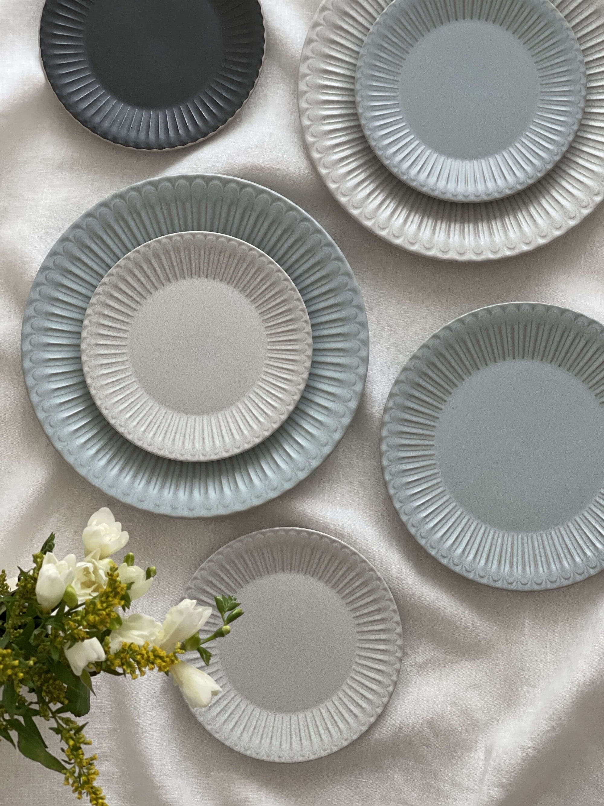 Elegant porcelain Storia plates with lace edges on a white backdrop, showcasing a nostalgic and romantic design.