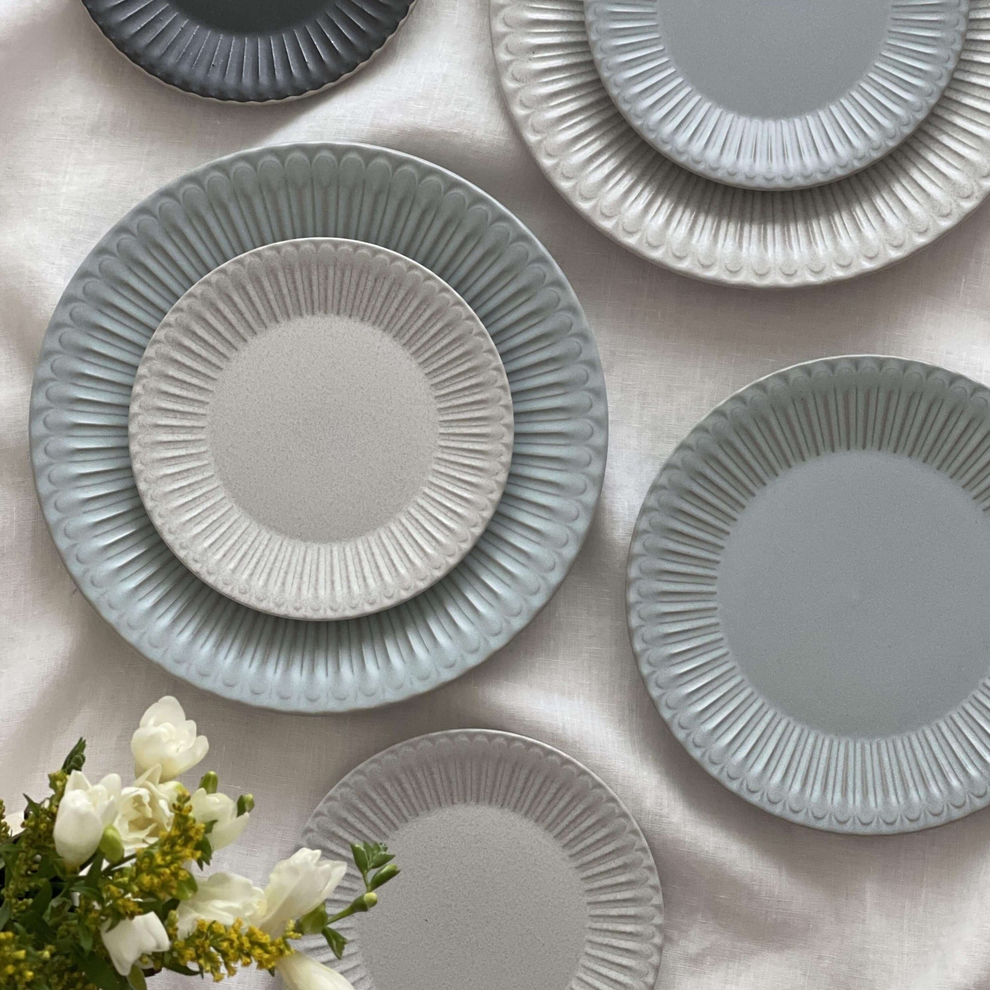Elegant Storia Plates 27cm with soft lace edge design, showcasing nostalgia and sophistication, arranged on a tablecloth.
