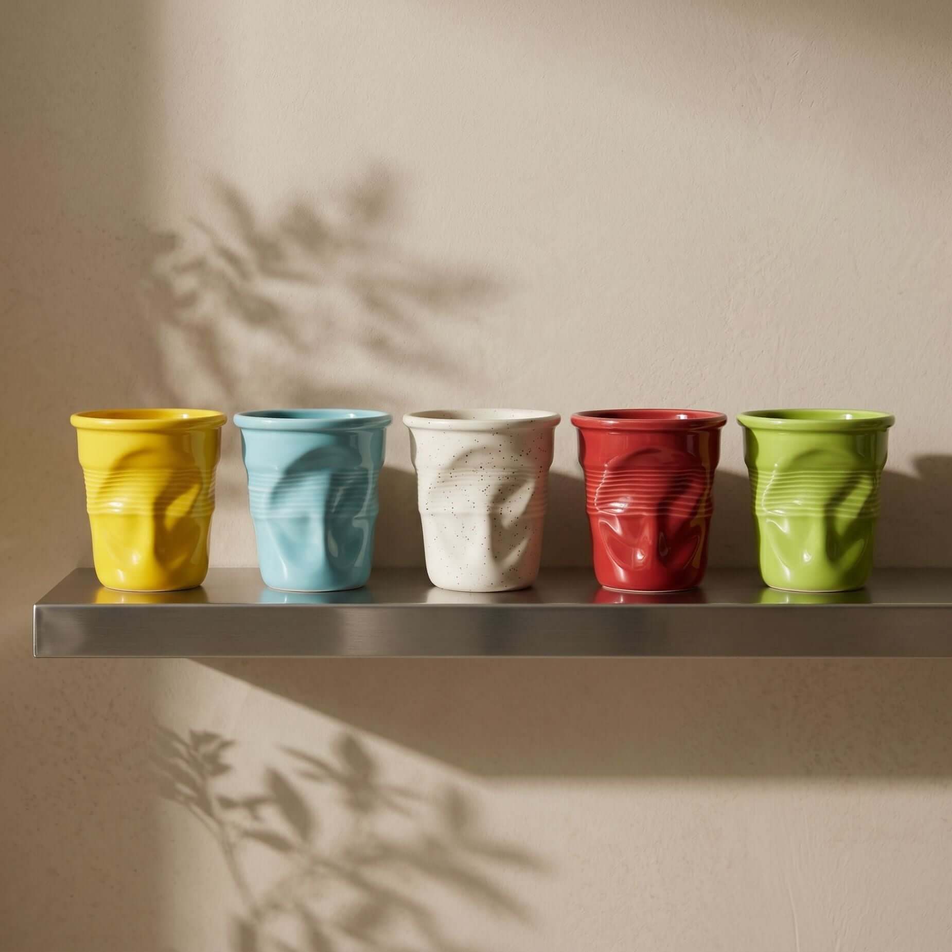 Crushed ceramic coffee mug held in soft morning light