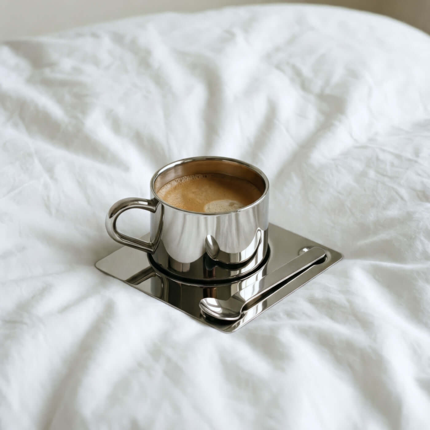 The Venice Mirror Cup — mirror-polished steel cup on a square saucer
