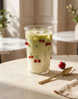 Tall Cherry Glass with matcha latte beside a spoon and a cherry