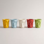 Crushed Ceramic Mugs in yellow, blue, beige, red and green in a row