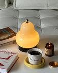 Lumi Poire Lamp glowing beside a stack of design books