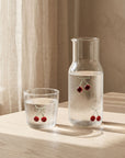 Cherry Glass Pitcher and cup with water on a linen-covered table