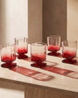 Red Sculpted Pedestal Glasses with light shining through