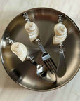 Shoreline Cutlery Set with shell handles on a round steel plate