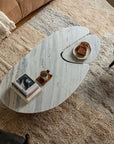 Modern Wabi-Sabi coffee table with natural wood and stone tabletop, featuring a smooth curved design in a cozy living area.