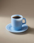 Powder Blue Pastel Muse Mug with coffee on its saucer