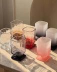 Sculpted Pedestal Glasses in clear, black and red on a stone table