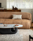 Modern living room with Wabi-Sabi coffee table featuring a wood and stone tabletop and unique curved base, in front of a beige sofa.