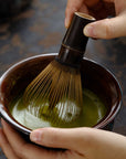 Hands whisking matcha with the Artisan Bamboo Matcha Whisk