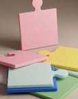Puzzle Pop Chopping Boards in pink, yellow, green and blue stacked together