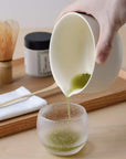 Pouring whisked matcha from the KASUMI bowl into a glass