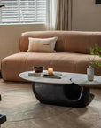 Modern Wabi-Sabi coffee table with wood and stone top, stylishly contrasting in a cozy living room setting.
