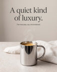 Double-Wall Glossy Stainless Steel Cup with coffee beside white linen, a quiet kind of luxury