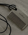 LoveÉcru Vintage Metal Comb with its black cord on a white cloth