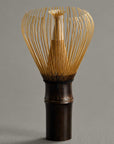 Artisan Bamboo Matcha Whisk in smoked bamboo, 100 prongs, standing upright