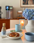 KASUMI Matcha Ritual Set in blue on a table with flowers and a pastry