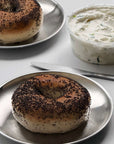 Stainless steel plate from the Set of Six with a poppy seed bagel and cream cheese