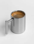 Bern Mirror Mug filled with coffee, mirror-polished stainless steel