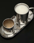 Milano Duo Set with a frothy latte in the tall cup on a black surface