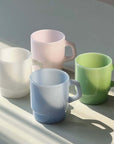 Pastel Muse Mugs in pink, blue and green on a counter