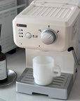 Classic White Pastel Muse Mug beside a cream espresso machine