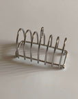Stainless Steel Toast Holder, six-slice rack casting a shadow on a wall