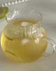 Clair Pitcher filled with lemonade and ice, showing its rounded glass body