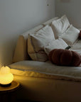 Lumi Poire Lamp glowing on the floor beside a sofa