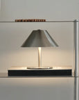 Atelier Halo Lamp lit on a steel shelf
