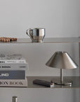 Atelier Halo Lamp on a glass shelf with books