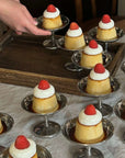 Elegant Dessert Cups with strawberry-topped puddings on a wooden table