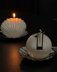 Dreamy Swing pearl candle lit on a shell plate with a trinket case