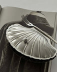 Vintage Shell-Shaped Silver Trinket Case on a magazine with a fork