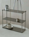 Modern Aira Stainless Shelf with minimalist design holding cups and decor on a smooth tabletop, showcasing sleek elegance.