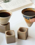 Two latte cups with coffee held over ceramic stands, the free latte cups from the Morning Bliss set