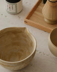 Hand-glazed Warm Sand matcha bowl with pouring spout, close-up