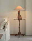 Custom-crafted wooden lamp on rustic side table next to white sofa in cozy living room setting.