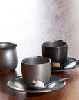 Vintage inox cup and saucer set with stainless steel finish, includes two cups with matching saucers on a wooden table.